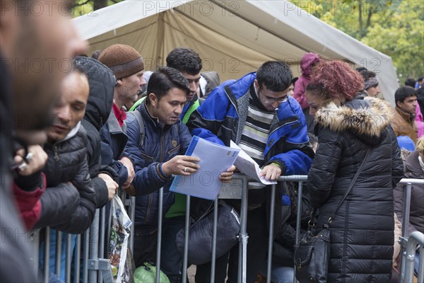 Refugees from Syria wait behind barriers in the Central Reception Centre for Asylum Seekers at the Berlin State Office for Health and Social Affairs for their registration, 09.10.2015