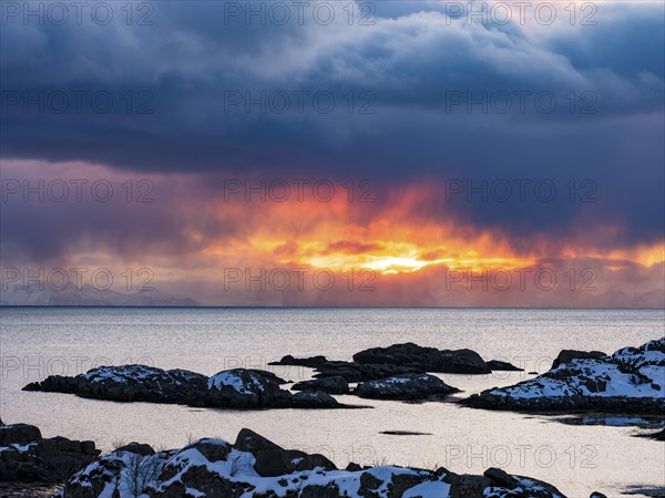 The sun shines through dense clouds on the coast of Ballstad, Vestvagoy Island, Lofoten, Norway, Europe