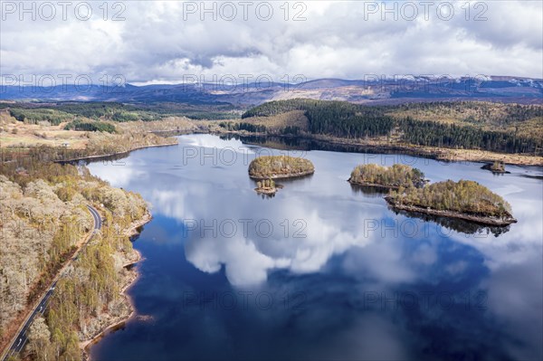 Clouds reflected in lake Loch Garry, islands on the mirrored sky, scottish highlands, aerial view, Scotland, UK