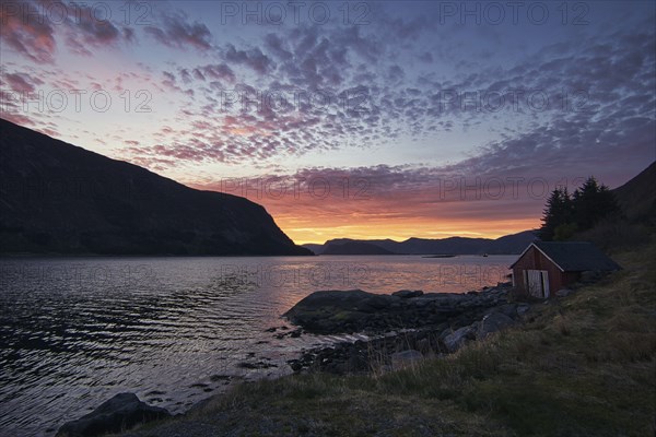 Sunset on the fjord of Selje Norway. very beautiful colors reflected in the clouds and the water. Fishing vacation in fantastic landscape