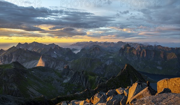 View over mountain top and sea, dramatic sunset, at the top of Hermannsdalstinden, Moskenesöy, Lofoten, Nordland, Norway, Europe