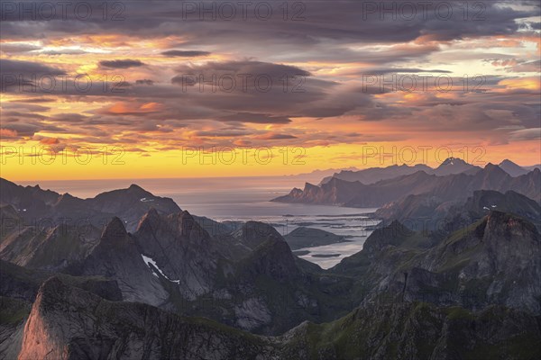 View over mountain top and sea to Fredvang, dramatic sunset, from the top of Hermannsdalstinden, Moskenesöy, Lofoten, Nordland, Norway, Europe