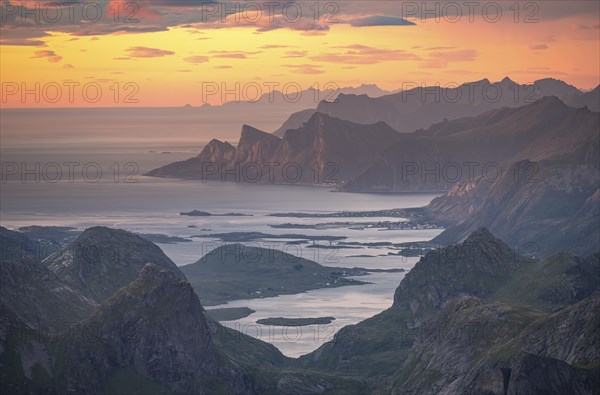 View over mountain top and sea to Fredvang, dramatic sunset, from the top of Hermannsdalstinden, Moskenesöy, Lofoten, Nordland, Norway, Europe