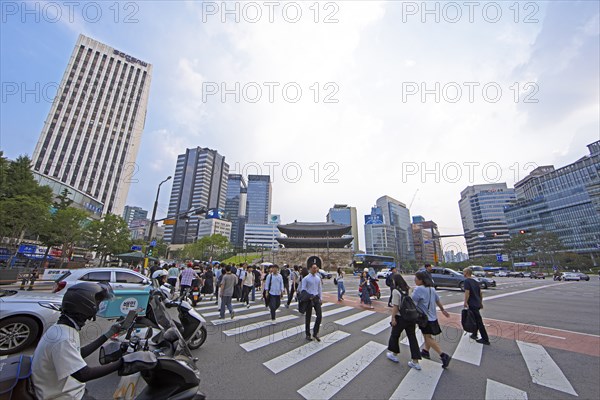 Koreans crossing the street, the historic Namdaemun City Gate or Great South Gate in the back and the skyscrapers of Seoul, Jung-gu, Seoul, South Korea, Asia
