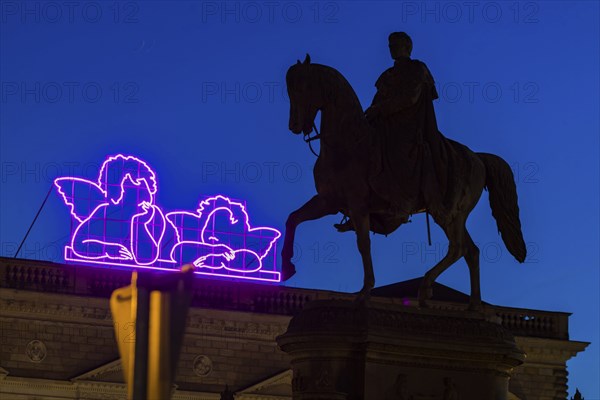 Equestrian statue of King John of Saxony on the evening theatre square. Since the reopening of the Old Masters Picture Gallery, Raphael's angels have been shining in neon colours on the Semper Building