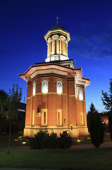 Illuminated church at night with a high tower, blue sky and visible windows. Craiova, Krajowa, Kragau, Church of St Treime, Holy Trinity Church, Bisceria Sfanta Treime, Small Wallachia, Romania, Europe