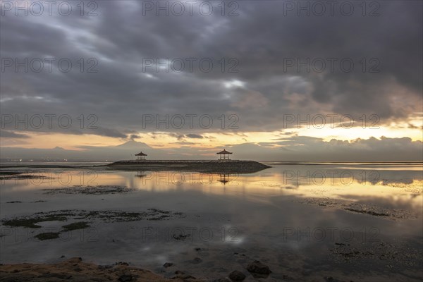Beautiful seascape in the morning. Tropical sandy beach with breakwater and reflection of the sky in the calm water. Morning landscape, taken in Sanur, Bali, Indonesia, Asia