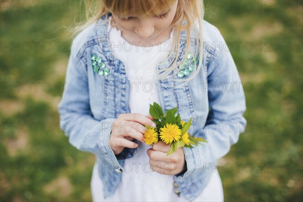 Small girl is holding Small girl is holding a bouquet with yellow flowers. a bouquet with yellow flowers.