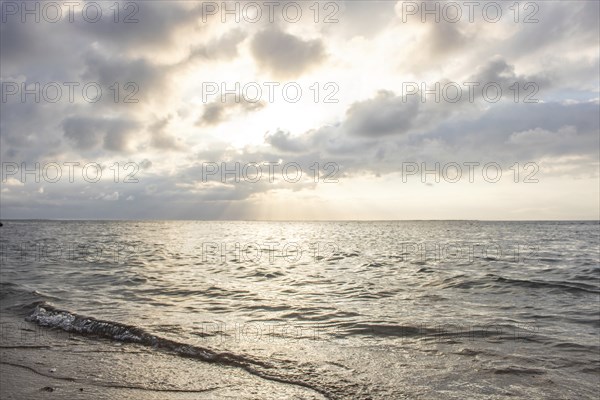 Beautiful seascape in the morning. Tropical sandy beach with breakwater and reflection of the sky in the calm water. Morning landscape, taken in Sanur, Bali, Indonesia, Asia