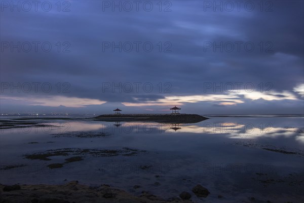 Beautiful seascape in the morning. Tropical sandy beach with breakwater and reflection of the sky in the calm water. Morning landscape, taken in Sanur, Bali, Indonesia, Asia