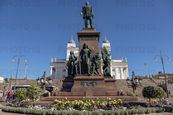White church with steps and a statue on a lively city square with blooming flowers and lanterns under a blue sky, Helsinki, Finland, Europe