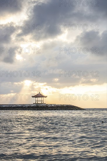 Beautiful seascape in the morning. Tropical sandy beach with breakwater and reflection of the sky in the calm water. Morning landscape, taken in Sanur, Bali, Indonesia, Asia