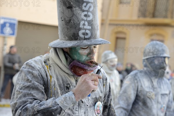 Man lighting firecracker with a cigar, Els Enfarinats flour fight, rebels, armed with flour, eggs and firecrackers, take over the regiment of the city for one day, Plaza de la Iglesia, Ibi, Province of Alicante, Costa Blanca, Spain, Europe