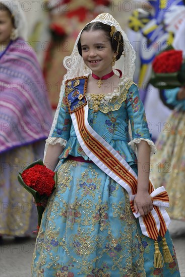 Fallas festival, girl in a traditional costume during the parade in the Plaza de la Virgen de los Desamparados, Valencia, Spain, Europe