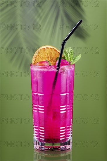Cold lemonade with dragon fruit, orange and coconut juice on green background