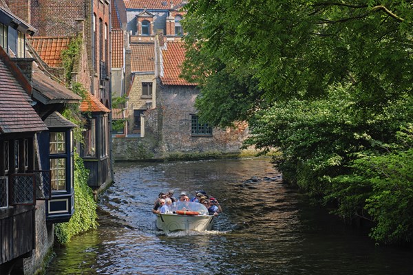 BRUGES, BELGIUM: Tourist boat with tourists in canal between old houses. Brugge Bruges, Belgium, Europe
