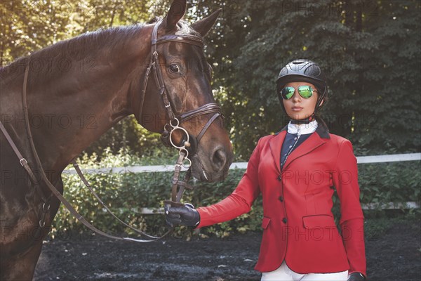 A young girl talking and takes care of her horse. She loves the animals and joyfully spends her time in their environment
