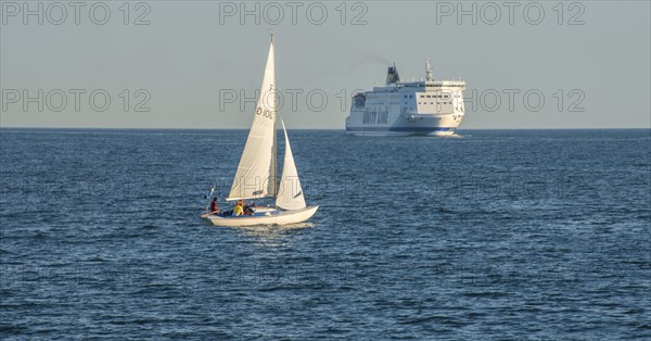 Sailboat and passenger ferry meet on the Baltic Sea outside Ystad, Sweden, Europe
