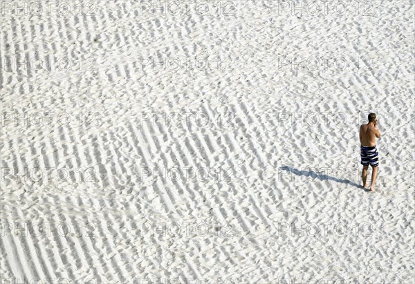A young man talks on the phone on the beach in Sellin, 13/09/2016