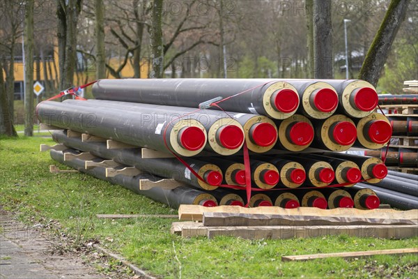 Pipe for district heating connections lying on a construction site on a stockpile, to be laid to supply buildings with district heating, North Rhine-Westphalia, Germany, Europe