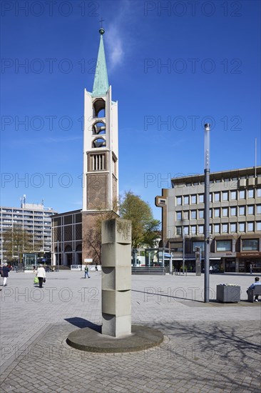 Old town church of the Ev. Emmaus parish against blue sky and stele at Heinrich-König-Platz in Gelsenkirchen, Ruhr area, independent city, North Rhine-Westphalia, Germany, Europe