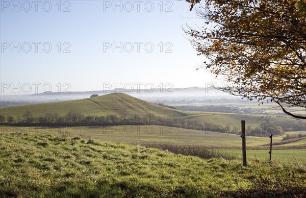 Picked Hill chalk outlier landscape misty valley floor, Vale of Pewsey, from Woodborough Hill, Wilcot, Wiltshire, England, UK