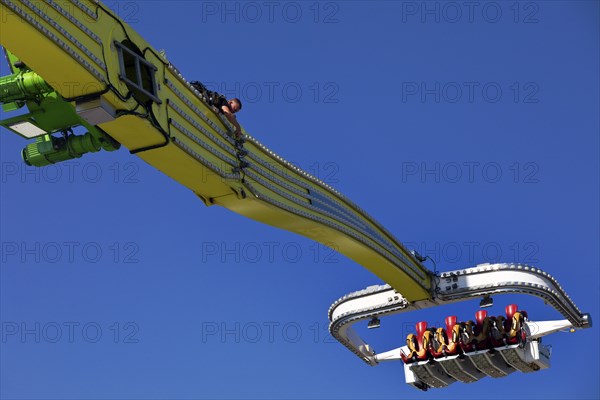 An employee works at the Chaos Pendulum ride at a dizzying height, Cranger Kirmes, Herne, Ruhr area, North Rhine-Westphalia, Germany, Europe