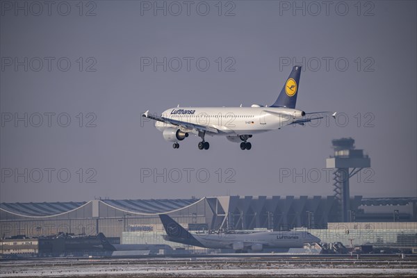 Lufthansa Airbus A320-200 approaching Frankfurt FRA airport, air traffic control tower, Fraport, in winter, Hesse, Germany, Europe