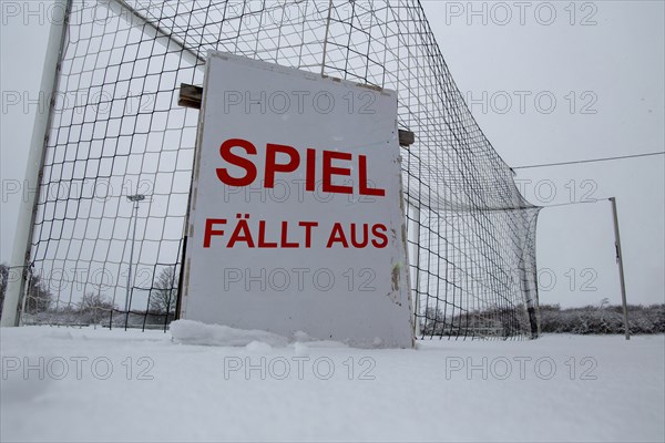 Symbolic image of a football match cancelled due to snow. Sign on a sports field with the inscription GAME CANCELLED