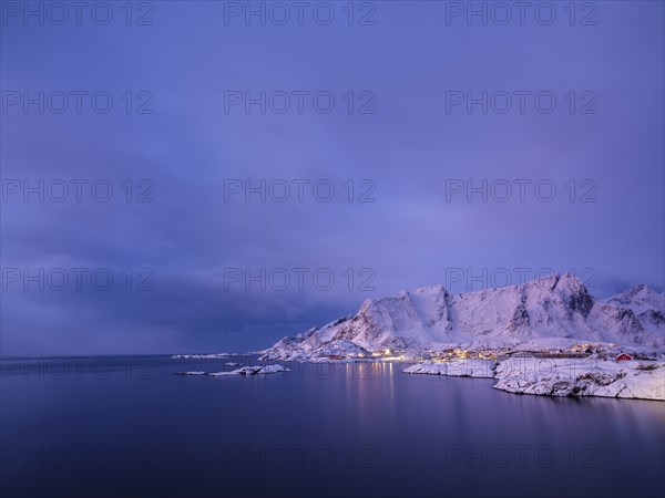 The village of Reine between snow-capped mountains and the sea at dawn, Reine, Moskenesøya, Lofoten, Norway, Europe