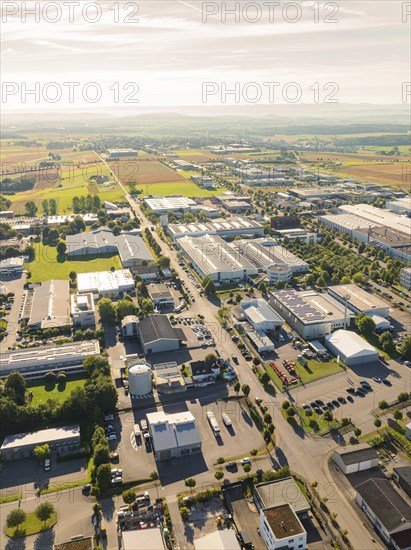 An industrial area with several factory buildings and neighbouring fields, seen from a bird's eye view in sunlight, Wolfsberg industrial area, Nagold, Black Forest, Germany, Europe