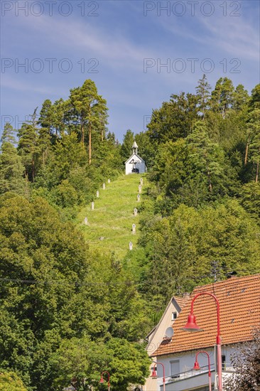 Small chapel on a hill in the forest, houses at the foot of the hill. Summer atmosphere, Gundringen, Nagold, Black Forest, Germany, Europe