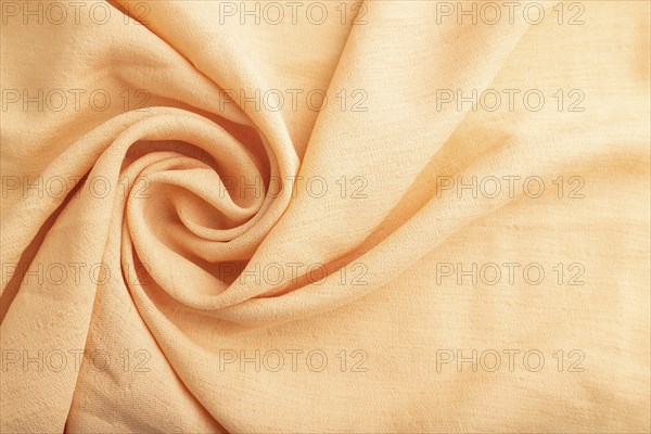 Fragment of orange linen tissue. Top view, flat lay, natural textile background and texture. wave concept, abstract, spiral form