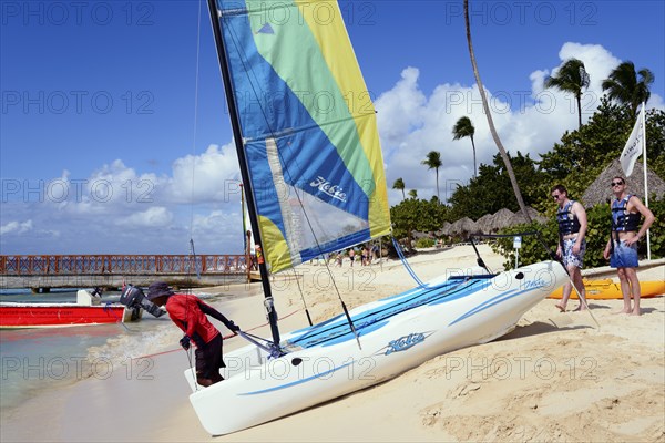 People rigging a catamaran on the beach under blue sky and palm trees, catamaran trip, Dominicus beach, Bayahibe, Dominican Republic, Hispaniola, Caribbean, America, Central America