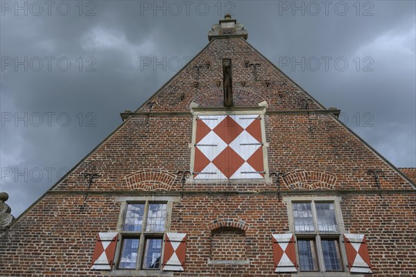 Close-up of a strikingly decorated gable of a historic brick building under a cloudy sky, Raesfeld, North Rhine-Westphalia, Germany, Europe