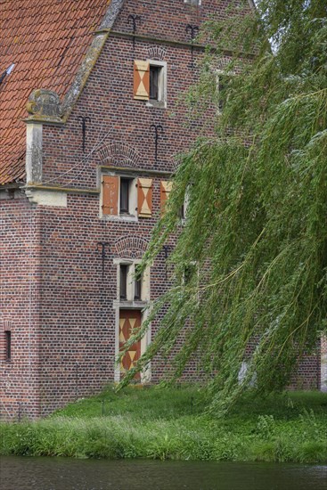 Detailed view of a medieval building with a red tiled roof and green trees in the background, Raesfeld, North Rhine-Westphalia, Germany, Europe
