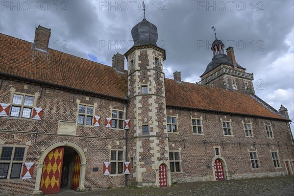 Medieval castle with red tiled roofs and towers under a cloudy sky, Raesfeld, North Rhine-Westphalia, Germany, Europe