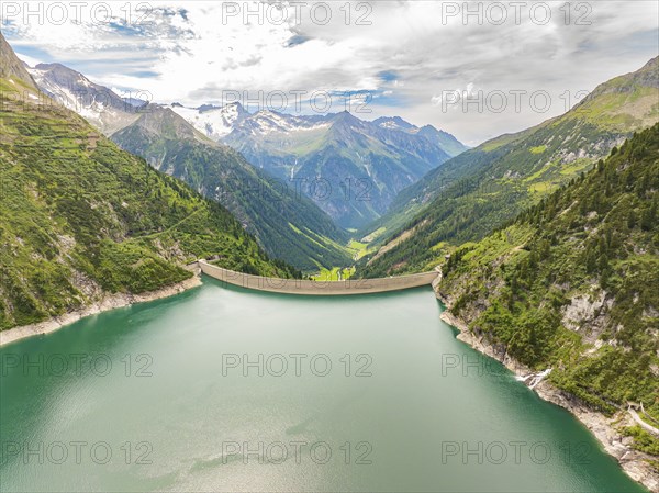 A reservoir with a dam, surrounded by mountains and green slopes, under a cloudy sky, Klein Tibet, Zillertal, Austria, Europe