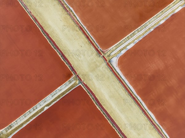 Saline ponds at the Bonanza salt works near Sanlúcar de Barrameda. The red colour depends on the level of salinity and is directly caused by the algae Dunaliella salina and brine shrimp. Aerial view. Drone shot. Cádiz province, Andalusia, Spain, Europe
