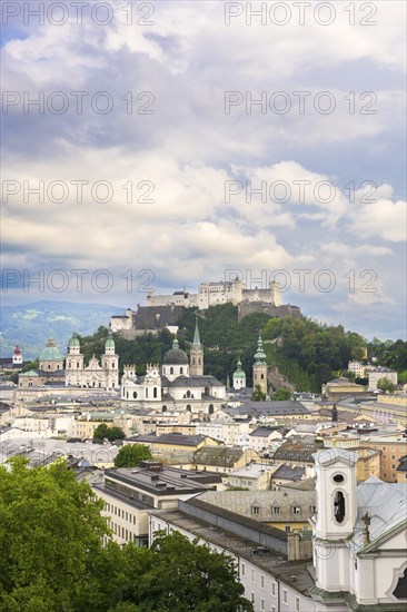 View of Salzburg with Hohensalzburg Fortress in the background and the historic city centre in the foreground, surrounded by mountains under a cloudy sky, Salzburg, Salzburger Land, Austria, Europe