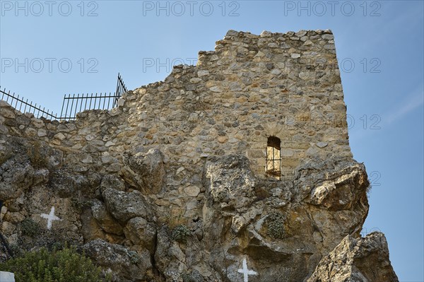 Historic stone wall with lattice and rocks, part of an ancient ruined architecture under a clear sky, St John's Castle, Archengelos village, Rhodes, Dodecanese, Greek Islands, Greece, Europe