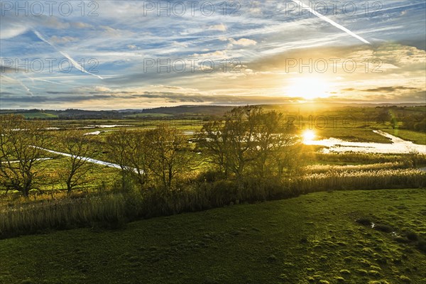 Sunset over Wetlands and Marshes in RSPB Exminster and Powderham Marshe from a drone, Exeter, Devon, England, United Kingdom, Europe