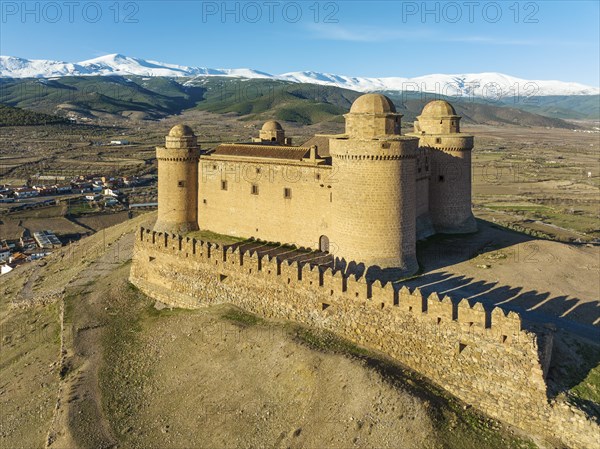 The Renaissance castle of La Calahorra against the snow-capped Sierra Nevada mountain range, aerial view, drone shot, Granada province, Andalusia, Spain, Europe
