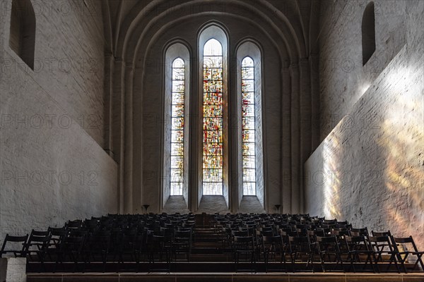 Lubeck, Germany, August 3, 2019: Stained glass window and chairs in the interior of the Cathedral, Europe