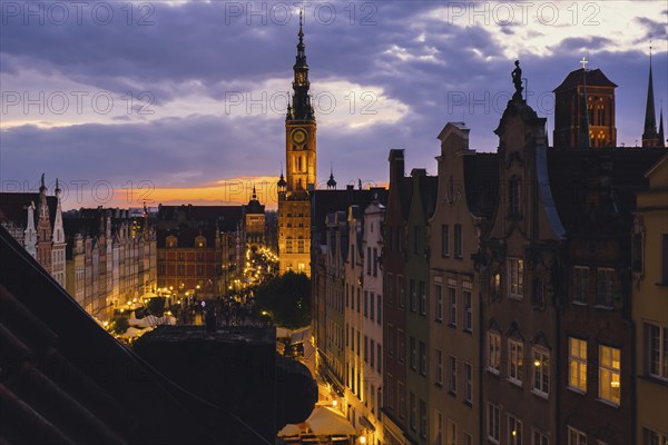 Beautiful old town in Gdansk at summer dusk Poland. Sunset night view from the window rooftop on historical centre Dluga street and city hall architecture buildings St Mary Basilica. Travel attraction tourist destination Dramatic sky