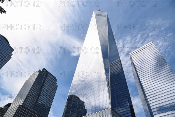 New York City, USA, June 20, 2018: One World Trade Center and other skyscrapers against blue sky in Financial District of Manhattan. Business and technology background, North America