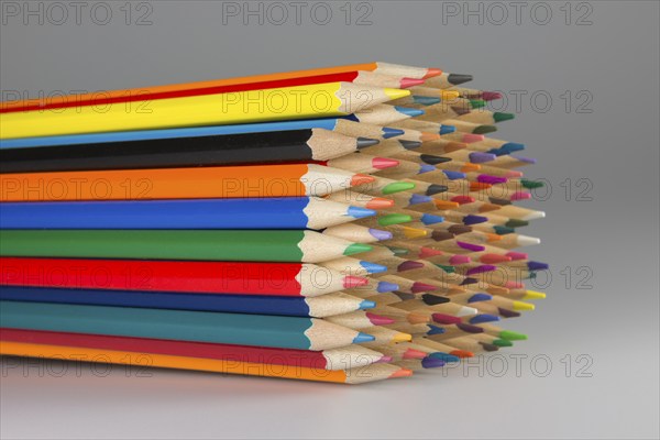 Abstract composition of a set wooden colour pencils against a white background