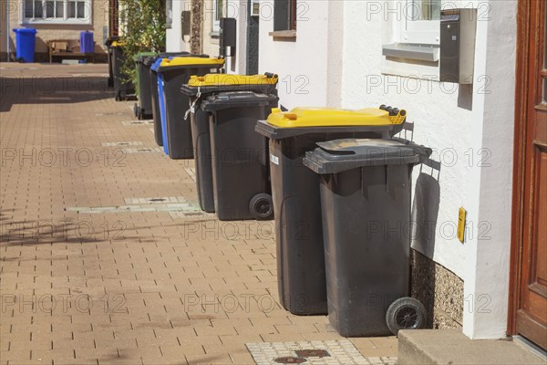 Various rubbish bins standing on the pavement in front of residential buildings, Hildesheim, Lower Saxony, Germany, Europe