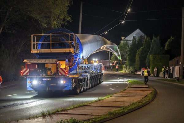 Transport of a 68 metre long, 22 tonne blade of a wind turbine, here in Schwelm, with a self-propelled Blade-Lifter vehicle, over a 40 km long route, over 2 nights, in the Bergisches Land, through towns, villages, over country roads, narrow through roads, to the construction site of the wind turbine near Hagen, North Rhine-Westphalia, Germany, Europe