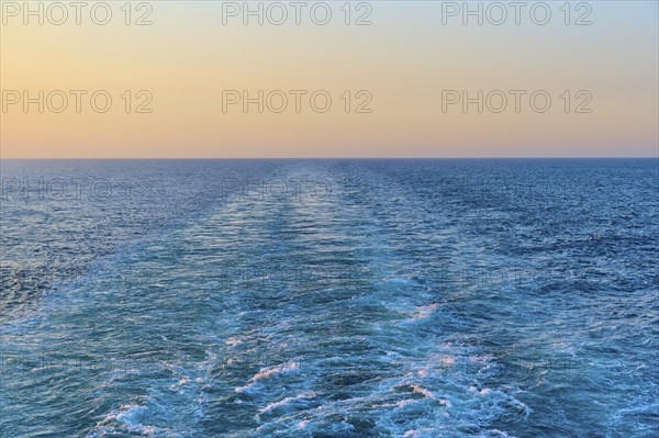 View from the cruise ship at sunset at the stern of the ship onto the stern waves, North Sea, Denmark, Europe
